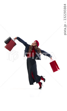 Stylish woman in red beret and navy jacket holding shopping bags in expressive pose Stylish woman in red beret and navy jacket holding shopping bags in expressive pose 132293864
