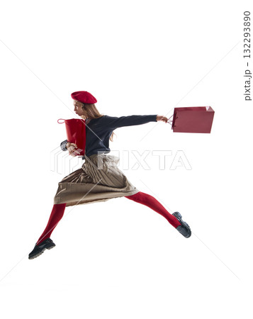 Fashion woman in red beret jumping with shopping bags and joyful motion isolated on white 132293890