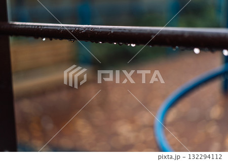 Raindrops on metal handrail with autumn bokeh 132294112