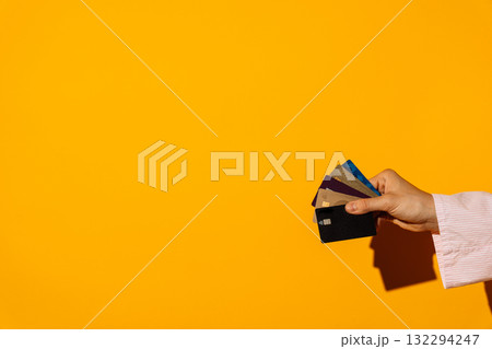 Hand fan of colorful contactless bank cards on yellow background Hand fan of colorful contactless bank cards on yellow background 132294247