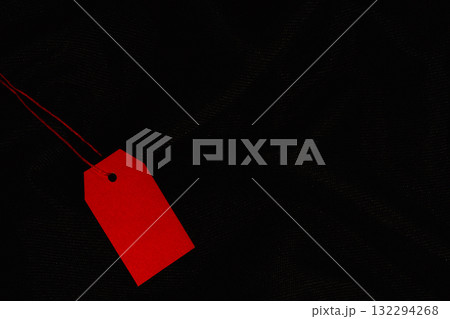 Red sale tag on black fabric background 132294268