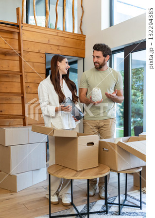 Couple feeling excited and happy while unpacking possessions in their new house 132294385