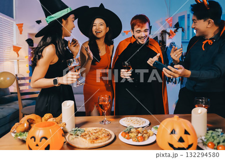 Joyful office Halloween party with coworkers in costumes, celebrating with drinks and laughter, fostering teamwork and festive spirit 132294580