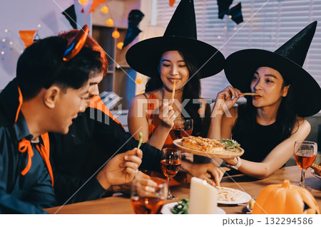 Joyful office Halloween party with coworkers in costumes, celebrating with drinks and laughter, fostering teamwork and festive spirit 132294586