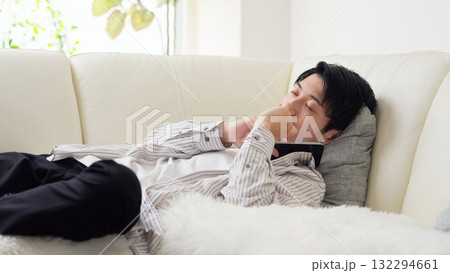 スマホを見ながら寝落ちするアジア人男性 132294661