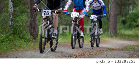 Three athletes ride in forest at mountain bike competition Three athletes ride in forest at mountain bike competition 132295253