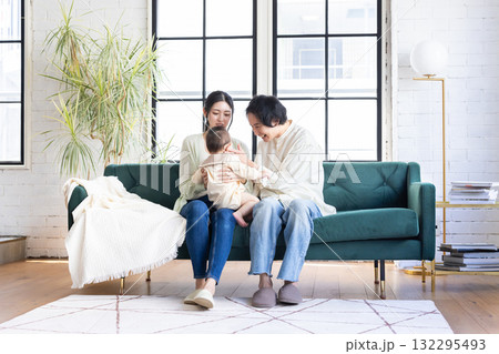 赤ちゃんを抱っこする夫婦 132295493