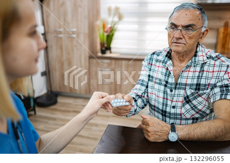 Elderly man gets meds in a cozy room Elderly man gets meds in a cozy room 132296055