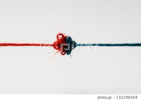 Red and blue yarn threads tied together symbolizing connection and unity 132296564