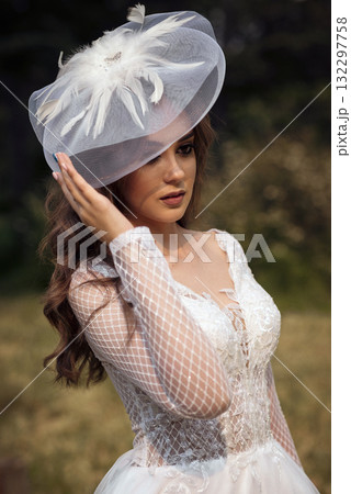 portrait of a young beautiful bride in a white dress and a white hat portrait of a young beautiful bride in a white dress and a white hat 132297758