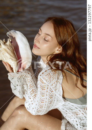 Young woman wear summer clothes hold shell near ear listen sound close eyes 132297797