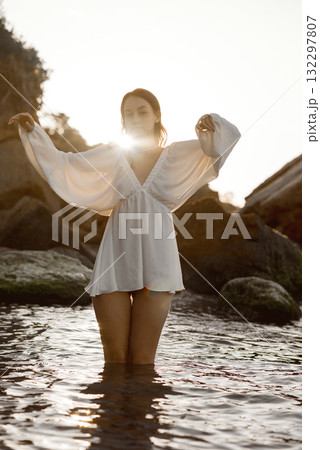 A woman standing next to a body of water A woman standing next to a body of water 132297807
