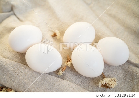 white eggs in a cardboard box, 10 pieces, on a surface made of natural materials. white eggs in a cardboard box, 10 pieces, on a surface made of natural materials. 132298114