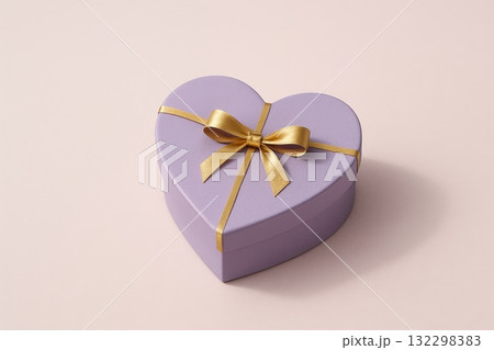 Heart shaped gift box with golden ribbon on pastel background, perfect for celebrations or special occasions. 132298383