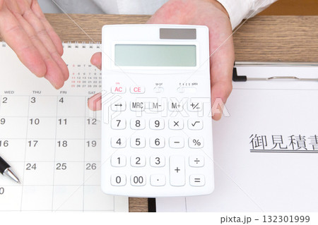 電卓を持つ人の手元 132301999