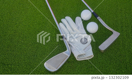 Golf clubs and balls on a green lawn in a beautiful golf course with morning sunshine. Golf clubs and balls on a green lawn in a beautiful golf course with morning sunshine. 132302109