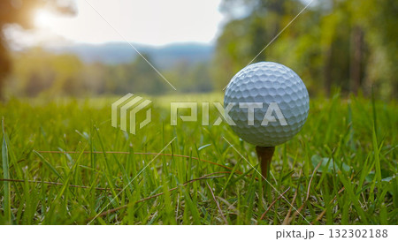Golf ball on green grass in the evening golf course with sunshine background. Golf ball on green grass in the evening golf course with sunshine background. 132302188