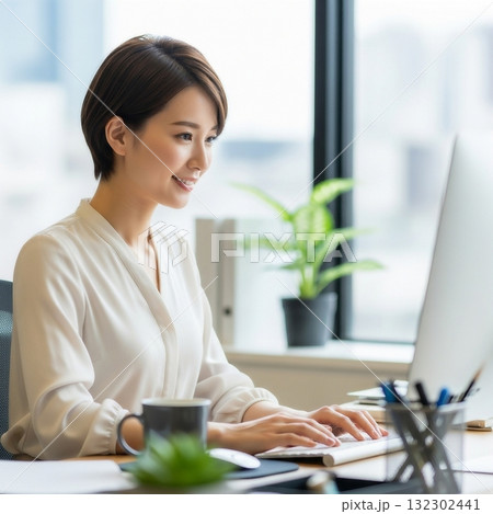 オフィスの中でパソコンで仕事をする若い日本人女性 132302441