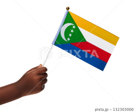 子供の手が小さなコモロの国旗を持っている。 132303000
