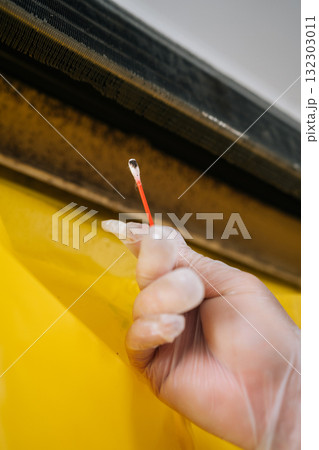 Vertical cropped shot of technician in gloves cleaning mold from dirty air conditioner with cotton swab, promoting proper hygiene and ensuring effective maintenance for improved indoor air quality. 132303011