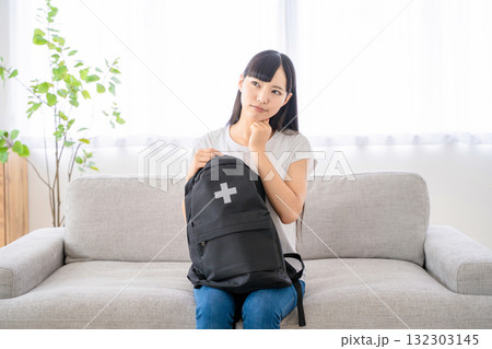 防災リュックを持つ若い女性 132303145