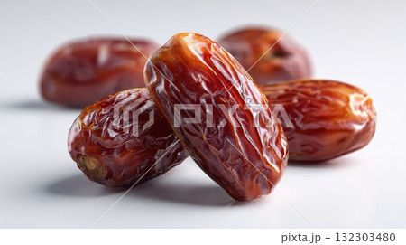 Fresh dried dates with wrinkled skin on white background, showcasing natural sweetness and healthy organic fruit snack for nutrition concepts 132303480
