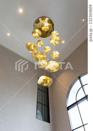 An elaborate, crystal chandelier in a hotel lobby or luxury home. An elaborate, crystal chandelier in a hotel lobby or luxury home. 132303604