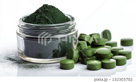 Spirulina powder in glass jar with green supplement tablets on white background, natural superfood for health and nutrition Spirulina powder in glass jar with green supplement tablets on white background, natural superfood for health and nutrition 132303702
