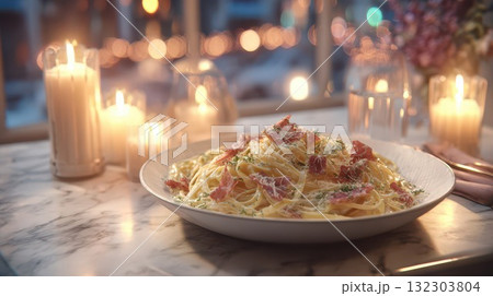 Elegant pasta carbonara with crispy prosciutto, parmesan cheese, and fresh herbs served on white plate with romantic candlelight ambiance in upscale restaurant setting. Fine dining experience 132303804