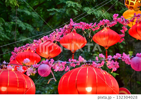 Close-up of the traditional Chinese red lantern with outdoor starry solar string lights. Big red lantern. Festive decoration. Mid-autumn festival, Chinese New Year decoration for celebration. Close-up of the traditional Chinese red lantern with outdoor starry solar string lights. Big red lantern. Festive decoration. Mid-autumn festival, Chinese New Year decoration for celebration. 132304028
