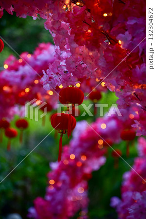 Close-up of the Chinese traditional red lantern decor with artificial peach blossom flower in outdoors. Festive decoration and celebration. Chinese New Year decoration. For background use. 132304672
