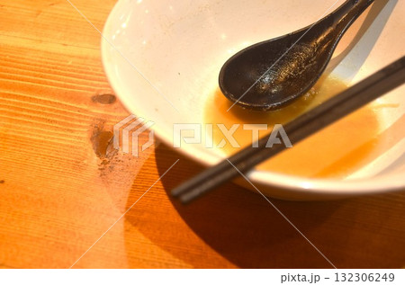 food stain and soup left after eat in bowl with chopsticks couple spoon on table food stain and soup left after eat in bowl with chopsticks couple spoon on table 132306249