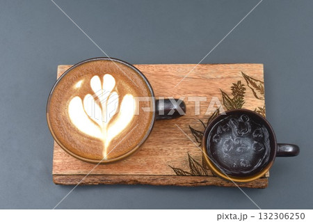 hot cappuccino coffee with latte art and cold ice water in cup on wooden board at table hot cappuccino coffee with latte art and cold ice water in cup on wooden board at table 132306250