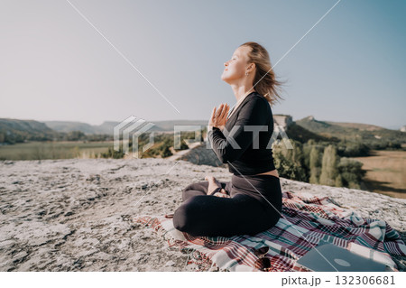 Woman Practicing Yoga on a Mountaintop 132306681