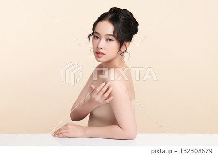 A beautiful young Asian woman with clean, fresh skin against a beige background. Skincare, facial treatment, cosmetology, beauty, and spa. An elegant portrait of an Asian woman. A beautiful young Asian woman with clean, fresh skin against a beige background. Skincare, facial treatment, cosmetology, beauty, and spa. An elegant portrait of an Asian woman. 132308679