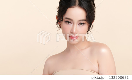 A beautiful young Asian woman with clean, fresh skin against a beige background. Skincare, facial treatment, cosmetology, beauty, and spa. An elegant portrait of an Asian woman. 132308681