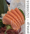 Fresh salmon sashimi served on ice with garnishes, showcasing vibrant colors and textures. This dish highlights delicate layers of fish, perfect for sushi lovers 132308816