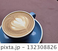 beautifully crafted latte with heart shaped foam design sits in blue cup on pink surface, inviting warmth and comfort 132308826