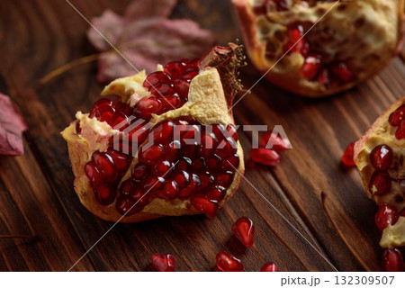 Pomegranate with Autumn Leaves on Dark Wooden Background Pomegranate with Autumn Leaves on Dark Wooden Background 132309507