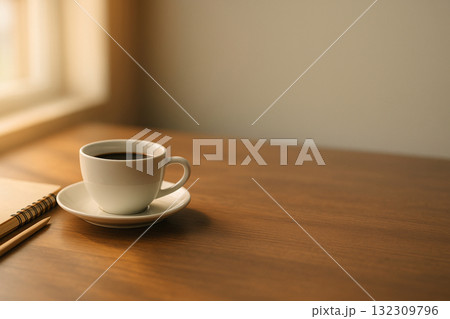 柔らかな朝の光に照らされたコーヒーカップとノートのコピースペース 柔らかな朝の光に照らされたコーヒーカップとノートのコピースペース 132309796