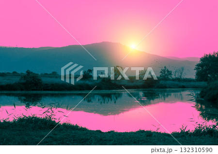 Mountain landscape in the evening. Beautiful lake against mountains. The Hula Valley in northern Israel at sunset 132310590
