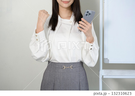 スマホを持ってガッツポーズをする日本人女性 132310623