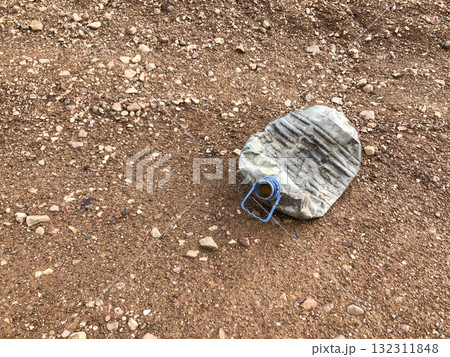 Crushed Plastic Water Container on Dirt Road as Environmental Pollution Concept 132311848