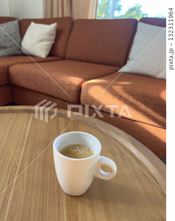 mug of coffee on wooden table in cozy living room with couch mug of coffee on wooden table in cozy living room with couch 132311964