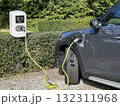 Electric car charging at outdoor station with yellow cable in eco-friendly park slot 132311968