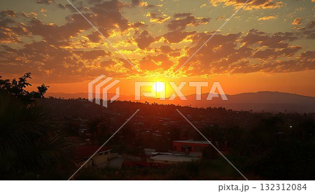 Fiery sunset over a sprawling cityscape with distant mountains a 132312084