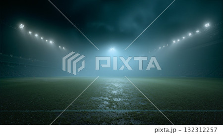 Football field enveloped in thick mist during evening hours, creating an eerie and mysterious atmosphere at the stadium 132312257