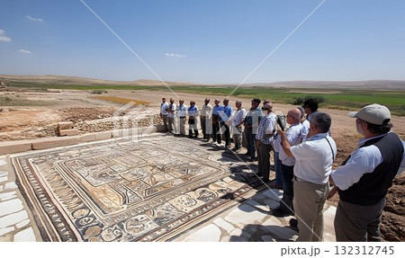 Group of tourists admiring the ancient mosaic floor in an archae 132312745