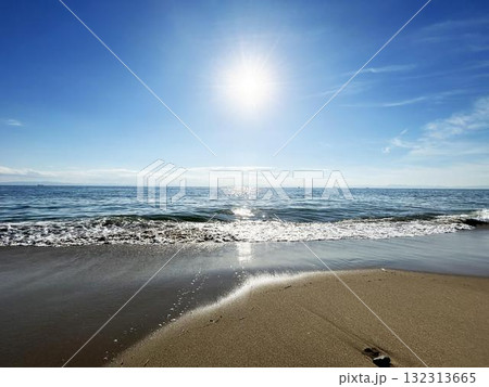 砂浜に打ち寄せる波と眩しい太陽 砂浜に打ち寄せる波と眩しい太陽 132313665