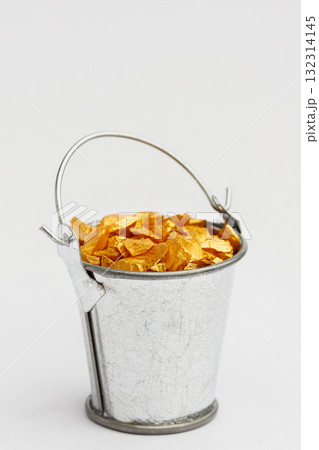 Small metal bucket filled with golden stones on white background. Concept of wealth 132314145